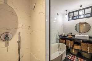 A bathroom with a shower, a bathtub, a sink, a mirror, and wicker baskets on shelves. - Charming Apartment With Terrace a/c 4P - Cannes (Cannes)