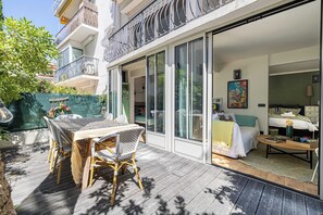 A modern apartment with a balcony, a dining area, and a bedroom with a bed and a desk. - Charming Apartment With Terrace a/c 4P - Cannes (Cannes)