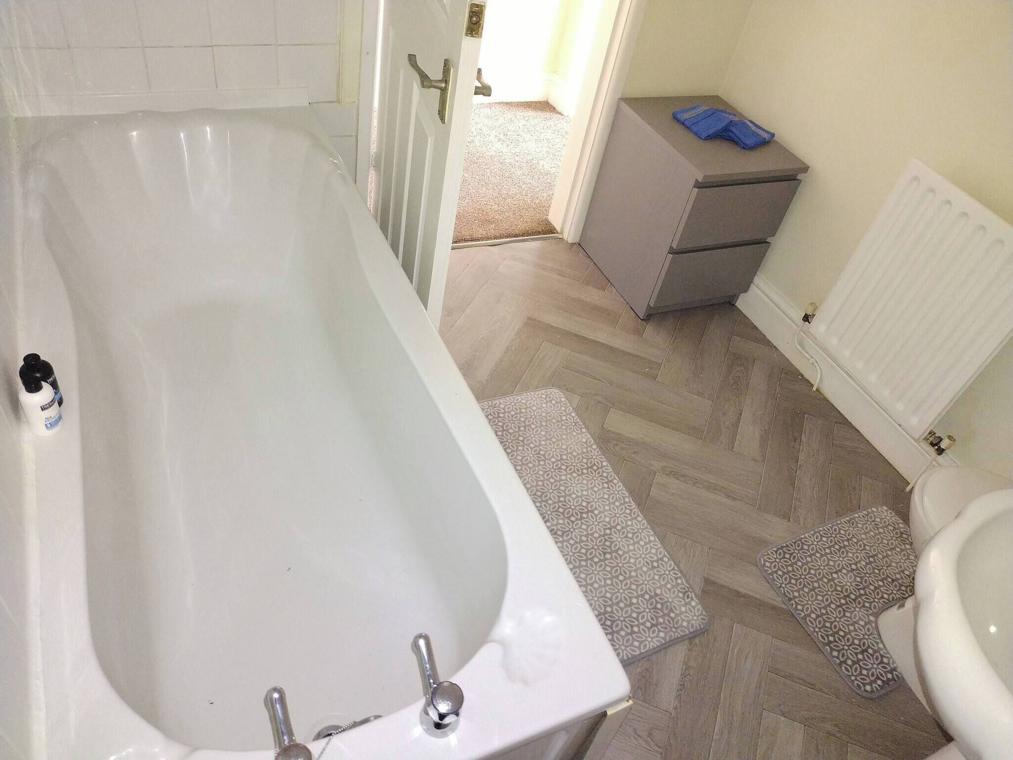 Un ba ño con bañera, inodoro y un pequeño armario.