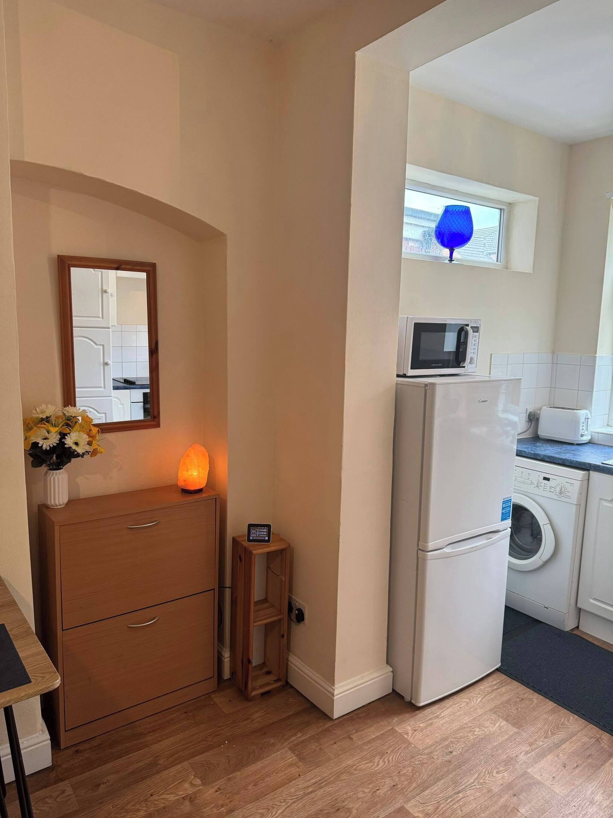 A compact kitchen with a microwave, toaster, and washing machine.