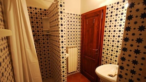 A bathroom with star-patterned tiles, a wooden door, and a white sink.