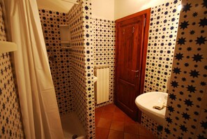 A bathroom with star-patterned tiles, a wooden door, and a white sink. - Villa Opera - Apartment in Livorno (Toscana)