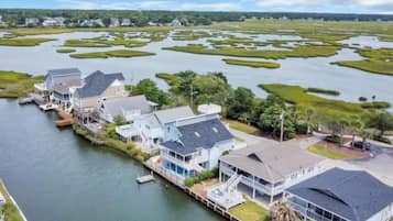 Une propriété située au bord de l’eau, comprenant plusieurs maisons reliées par des quais et entourée d’un paysage marécageux.