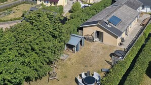 Un quartier résidentiel avec des maisons, un petit plan d’eau et des éoliennes en arrière-plan.