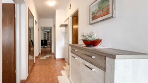 Ein Flur mit Holzboden, einer Küchenzeile und einem gerahmten Gemälde an der Wand.