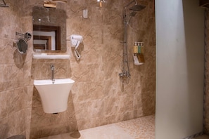 Een aparte badkuip en douche, een haardroger, handdoeken, zeep