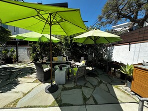A patio area with outdoor furniture, umbrellas, and potted plants. - Adorable Venice home in sought after Silver Triangle - walk to everything! (Los Angeles)