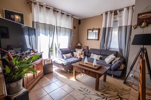 A cozy living room with a sofa, coffee table, and a television. - Alyxia's Villa - LA BASTIDE-PUYLAURENT (LA BASTIDE-PUYLAURENT)