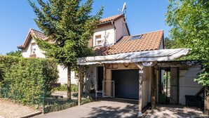 A building with a tiled roof, a covered entrance, and a fenced garden area. - Alyxia's Villa - LA BASTIDE-PUYLAURENT (LA BASTIDE-PUYLAURENT)