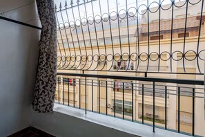 A balcony with a metal railing and a view of neighboring buildings. - Elegant family 2br flat, secure 24/7, quiet area (Tangier)