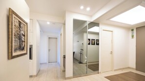 Un couloir avec un tableau encadré, une porte et un placard avec des portes miroir.
