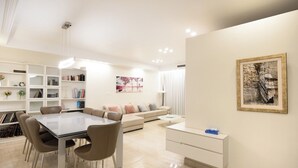 Un salon moderne avec une table à manger, un canapé et une bibliothèque.