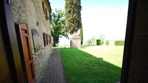 A stone building with a paved walkway leading to a grassy area. - Villa Opera - Apartment in Massa Carrara (Toscana)