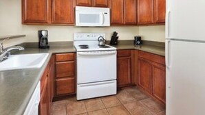 A kitchen with wooden cabinets, a white stove, a microwave, and a coffee maker. - Wyndham South Shore Resort condo in Zephyr Cove with kitchen and more! (Zephyr Cove)
