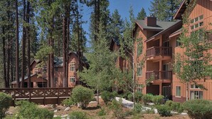 A multi-story lodge with a wooden exterior, surrounded by tall pine trees. - Wyndham South Shore Resort condo in Zephyr Cove with kitchen and more! (Zephyr Cove)
