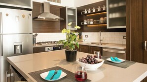 Una cucina moderna con isola centrale, elettrodomestici in acciaio inossidabile e mobili in legno.