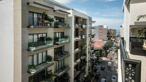 Un edificio a più piani con balconi, ampie finestre e vista sulla strada e sull'oceano.
