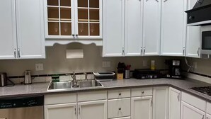 A kitchen with white cabinets, a stainless steel sink, a coffee maker, and a microwave. - Spacious 3-bedroom Townhome in Superb Baltimore Location with AC and Comfort (Baltimore)