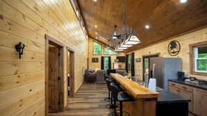 Ein Holzinterieur mit Küche, Bar und Sitzgelegenheiten.