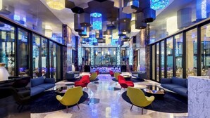 A modern lobby with a central bar area, seating arrangements, and a distinctive ceiling design. - Garza Blanca Resort & Spa Los Cabos 2-Bedroom Hotel Suite (Cabo San Lucas)
