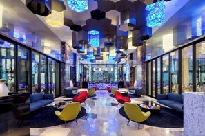 A modern lobby with a central bar area, seating arrangements, and a distinctive ceiling design. - Garza Blanca Resort & Spa Los Cabos 2-Bedroom Hotel Suite (Cabo San Lucas)