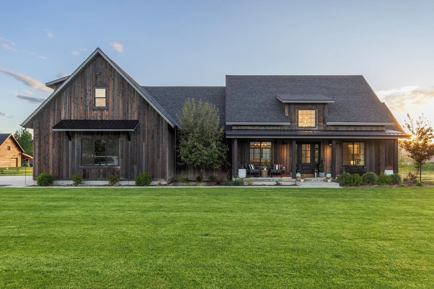 A two-story house with a large front lawn and a wooden exterior.