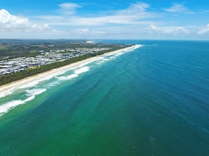 Vista aérea de una zona costera con una extensa playa y el océano.