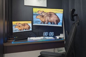 Ein Dual-Monitor-Setup mit einem Laptop, Tastatur, Maus und einer digitalen Uhr, die 88:88 anzeigt.