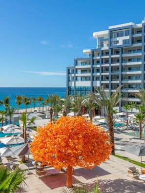 Ein Hotel mit Pool, Palmen und Blick aufs Meer.