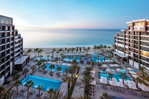 A resort with multiple swimming pools, palm trees, and a view of the beach. - Luxury 2 Bedroom Balcony Suite - Dec. 14-19th at Garza Blanca Los Cabos - 5 Star (Cabo San Lucas)