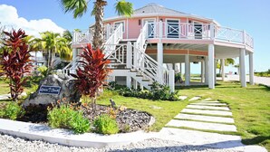 Un edificio rosa con una escalera blanca y un letrero que dice 'Leisure Beach'.
