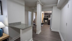 Een moderne keuken met donker houten vloeren, witte muren en een granieten aanrecht.