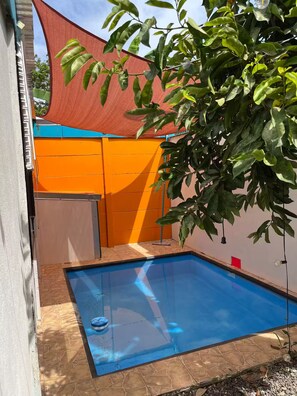A swimming pool with a clear blue surface, surrounded by a tiled deck. - Entire Downtown Home with Private Pool & A/C (Uvita)