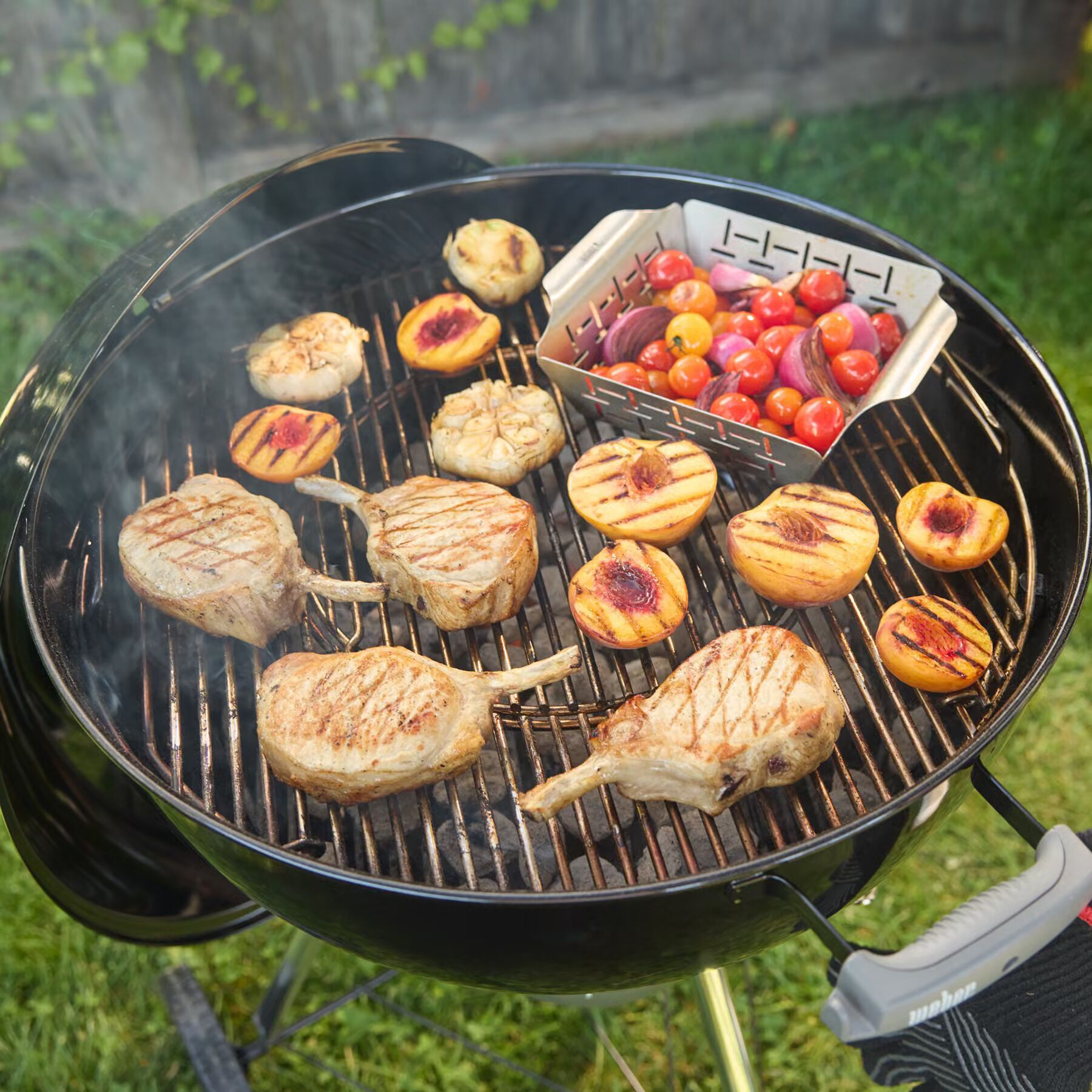 Een barbecue met verschillende vleessoorten en groenten die gebraden worden.