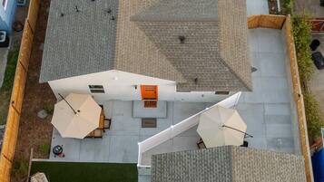 Una terraza con un pequeño avión, asientos al aire libre y una zona pavimentada.