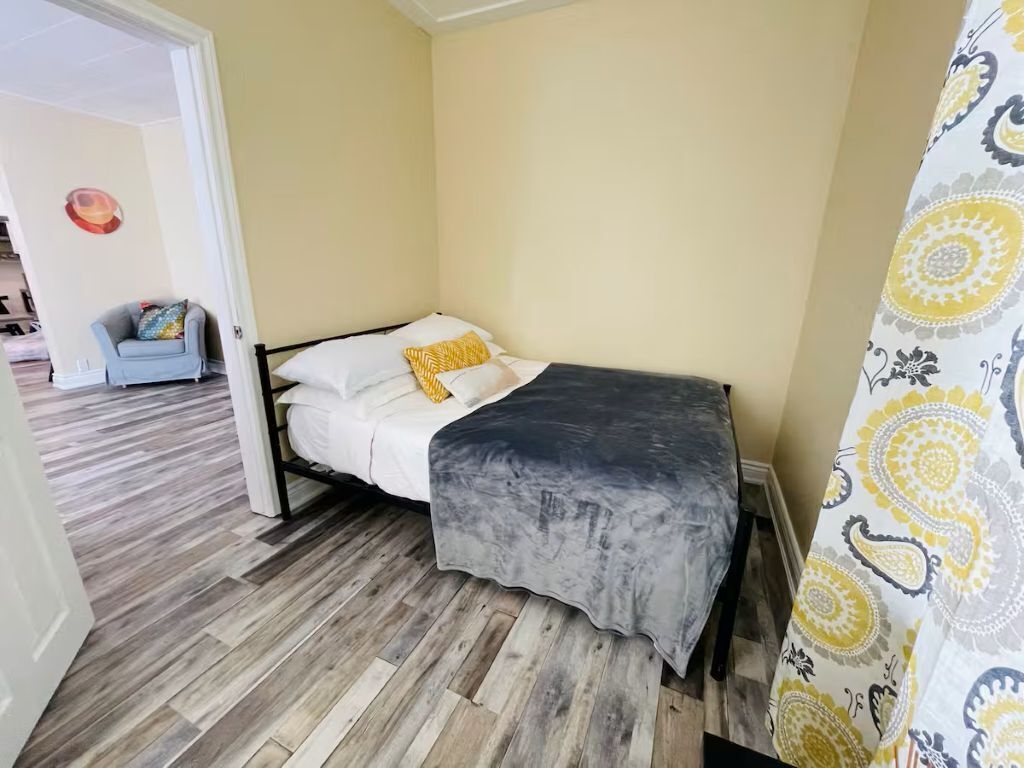Une chambre à coucher avec un lit, une chaise et un rideau à motifs.