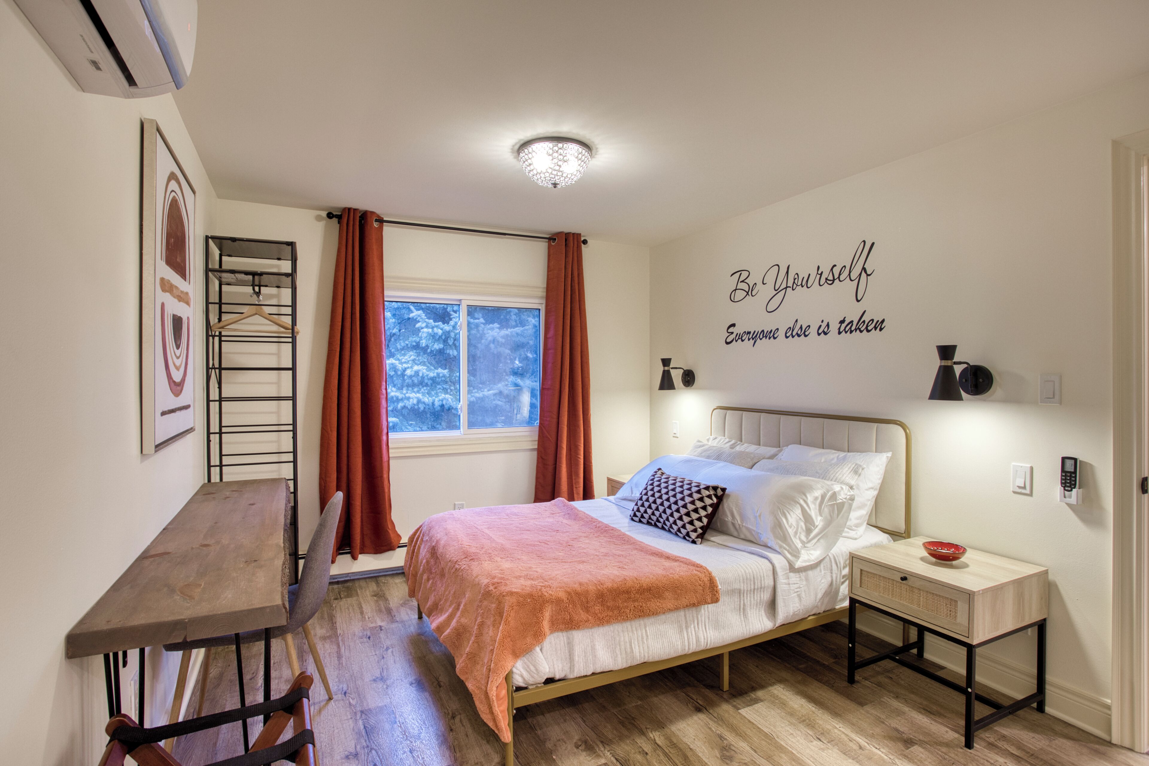 A bedroom with a bed, bedside table, and a wall-mounted shelf.