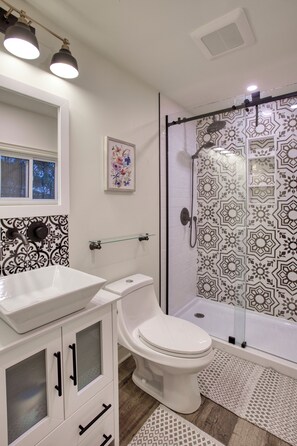Tweepersoonskamer | Badkamer | Een haardroger, handdoeken, zeep, shampoo