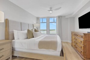 Ein Hotelzimmer mit Bett, Kommode, Fernseher und einem Fenster mit Blick.