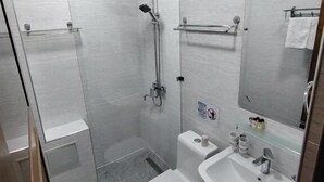 A modern bathroom with a glass shower enclosure, a toilet, a sink, and a mirror. - Nodirabegim Boutique Hotel (Bukhara)