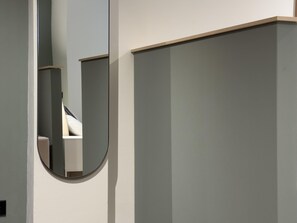 Een moderne badkamer met een grote spiegel, toilet en wastafel.