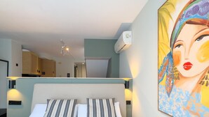 A hotel room with a bed, two pillows, a painting, and a ceiling light. - Málaga Apartments by Charming VII - Studio with terrace (Málaga)