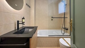 A modern bathroom with a black sink, a bathtub, and a shower. - Málaga Apartments by Charming VII - Studio with terrace (Málaga)