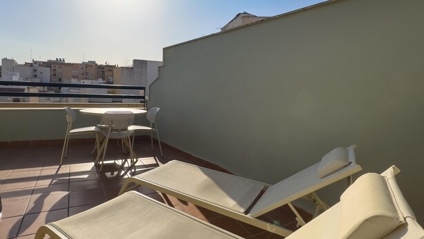 A rooftop terrace with a table and chairs, a sunshade, and a view of the cityscape. - Málaga Apartments by Charming VII - Studio with terrace (Málaga)