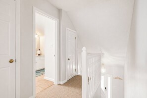 Ein heller Gang mit einer Tür zu einem Badezimmer.