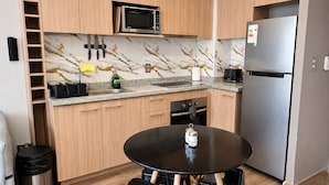 A compact kitchen with a microwave, oven, and refrigerator. - Apartment Just Steps from Line 1, the Bus Terminal, and the Train Station (Estación Central)