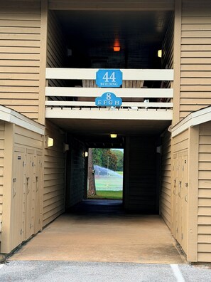 A covered walkway leading to a building with lockers on either side and a sign indicating '44 Building' and '8 EFH'. - Vita al Mare @ Seascape Resort (Miramar Beach)