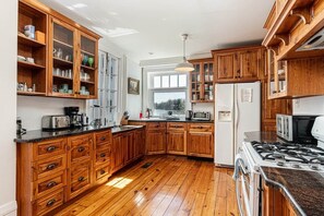 A kitchen with wooden cabinets, a stove, and a refrigerator.