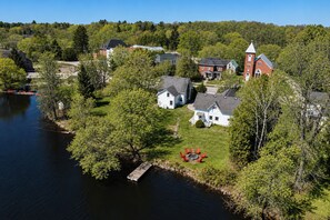 A lakeside residential area with houses, a dock, and a church.