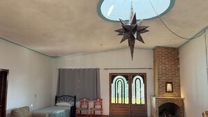 Una habitación con una cama, un sofá, dos sillones, una chimenea y un adorno colgante en forma de estrella.